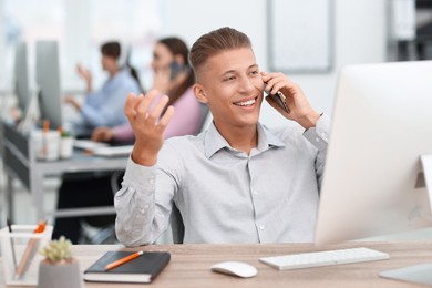 Photo of Salesman talking on phone at desk in office