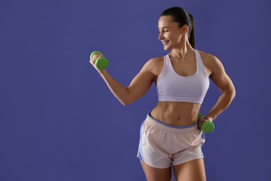 Photo of Woman exercising with dumbbells on purple background, space for text