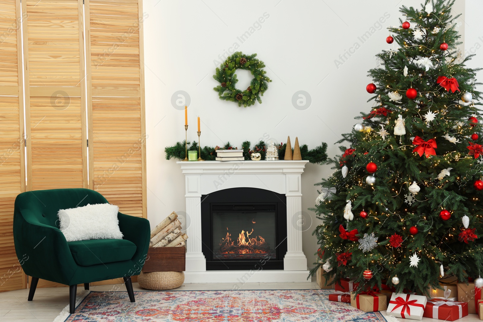 Photo of Decorated Christmas tree near fireplace in room. Festive interior design