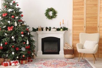 Photo of Decorated Christmas tree near fireplace in room. Festive interior design