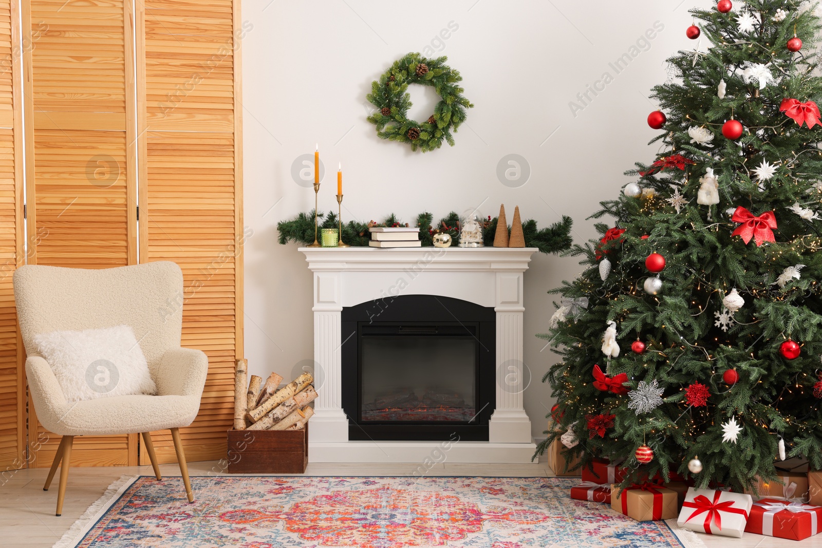 Photo of Decorated Christmas tree near fireplace in room. Festive interior design