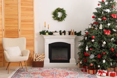 Decorated Christmas tree near fireplace in room. Festive interior design