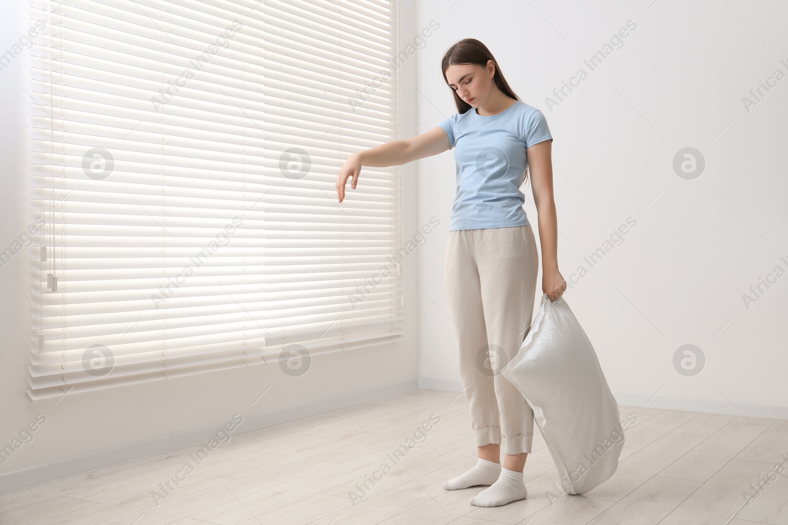 Photo of Young woman suffering from sleepwalking at home, space for text