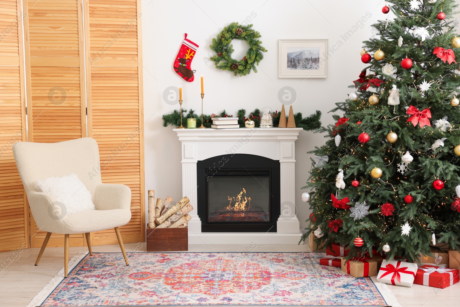 Photo of Decorated Christmas tree near fireplace in room. Festive interior design