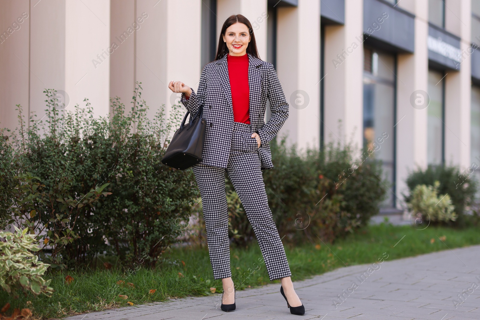 Photo of Smiling businesswoman in stylish suit on city street