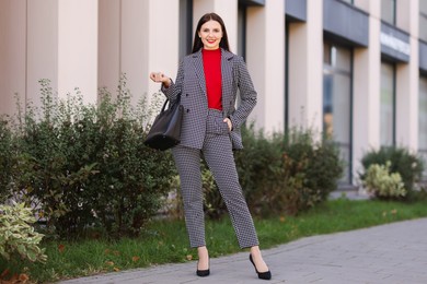 Photo of Smiling businesswoman in stylish suit on city street