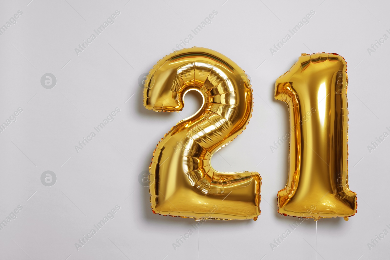 Photo of Coming of age party - 21st birthday. Number shaped balloons on light grey background, space for text