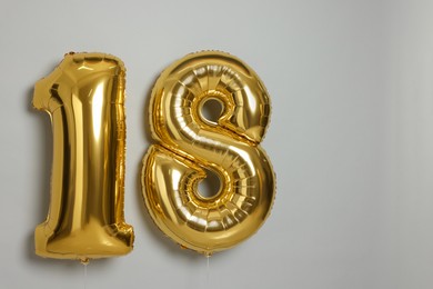 Photo of Coming of age party - 18th birthday. Number shaped balloons on light grey background, space for text