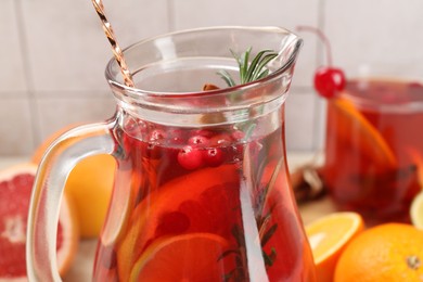 Photo of Delicious punch with rosemary in jug, closeup