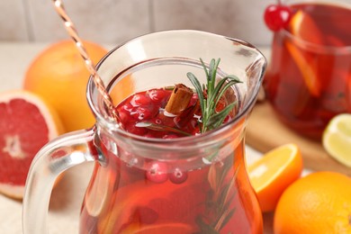 Photo of Delicious punch with rosemary in jug, closeup