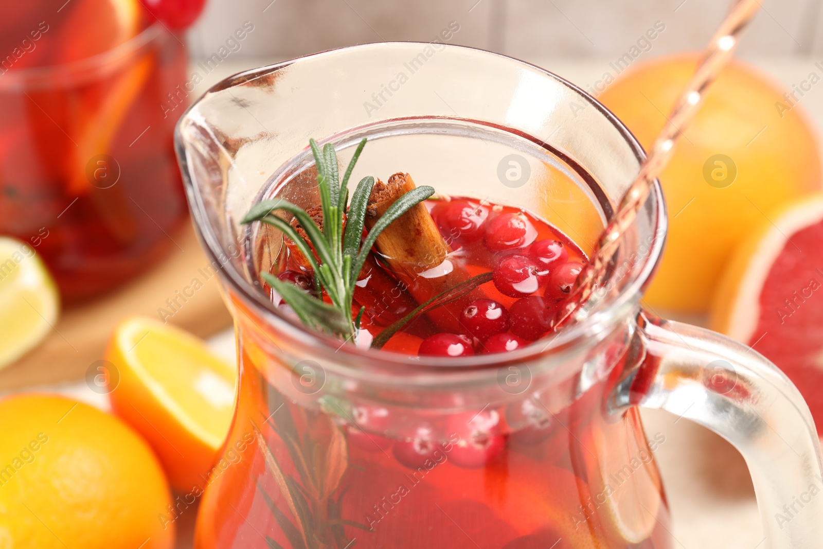 Photo of Delicious punch with rosemary in jug, closeup