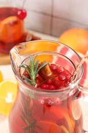 Photo of Delicious punch with rosemary in jug, closeup