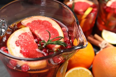 Photo of Delicious punch with rosemary in jug, closeup