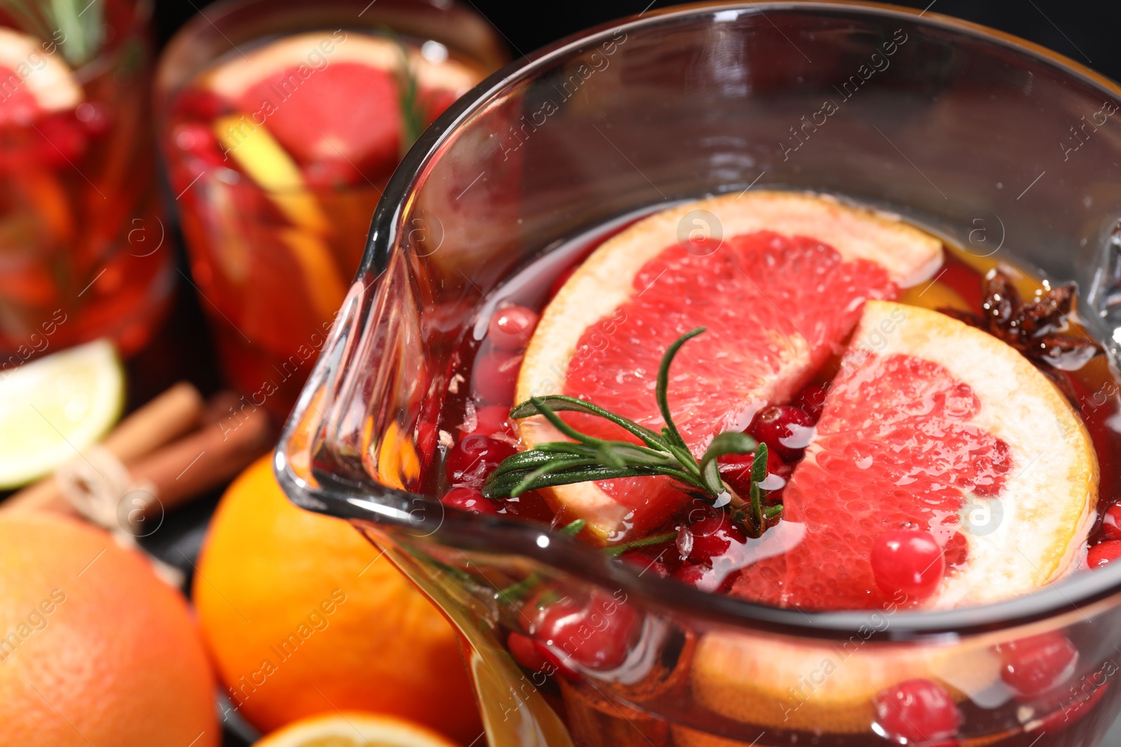 Photo of Delicious punch with rosemary in jug, closeup