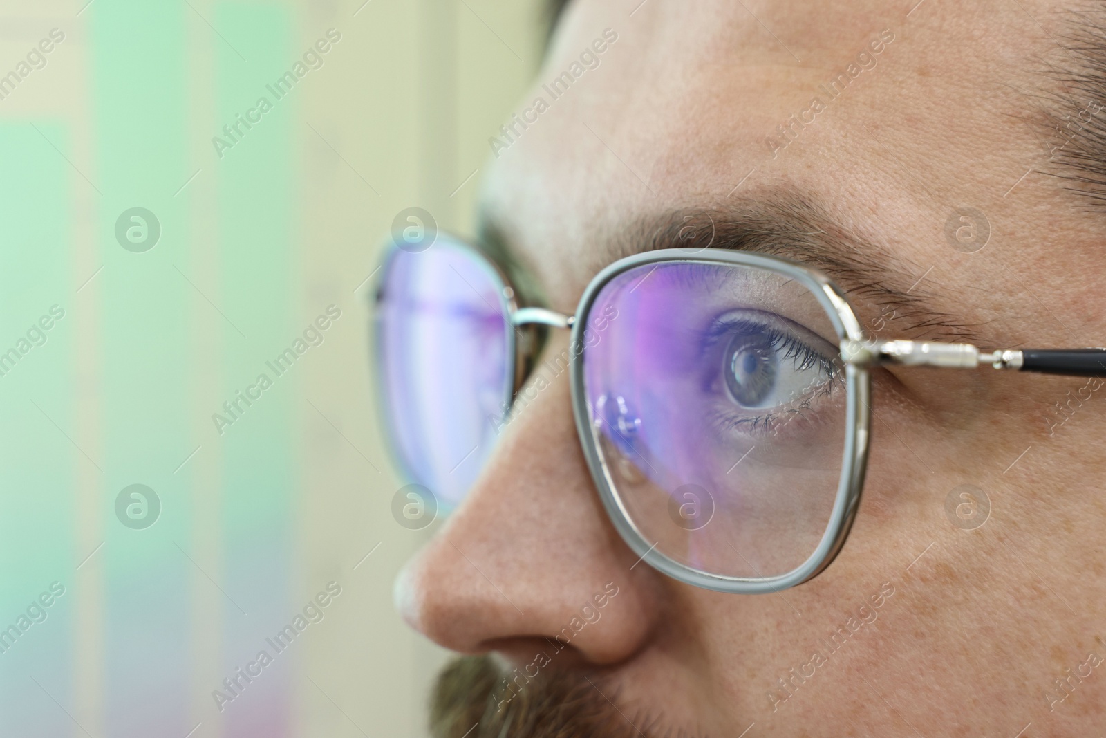 Photo of Man wearing stylish glasses on blurred background, closeup