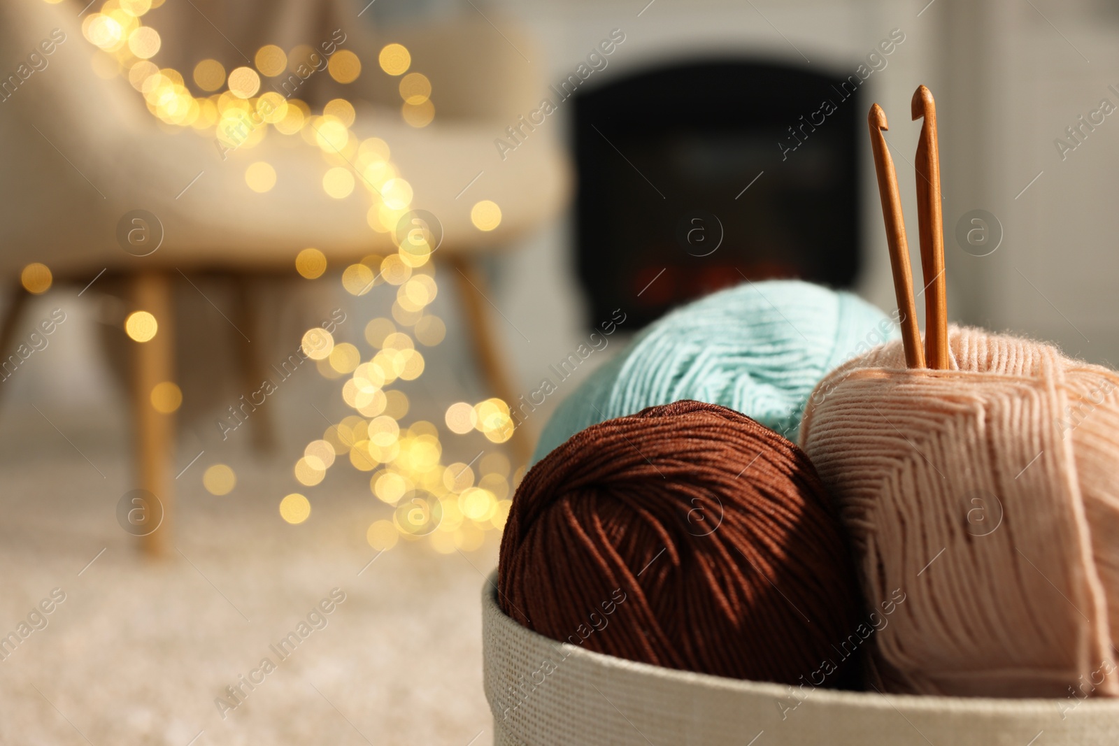 Photo of Box with colorful yarns and crochet hooks indoors, closeup. Space for text