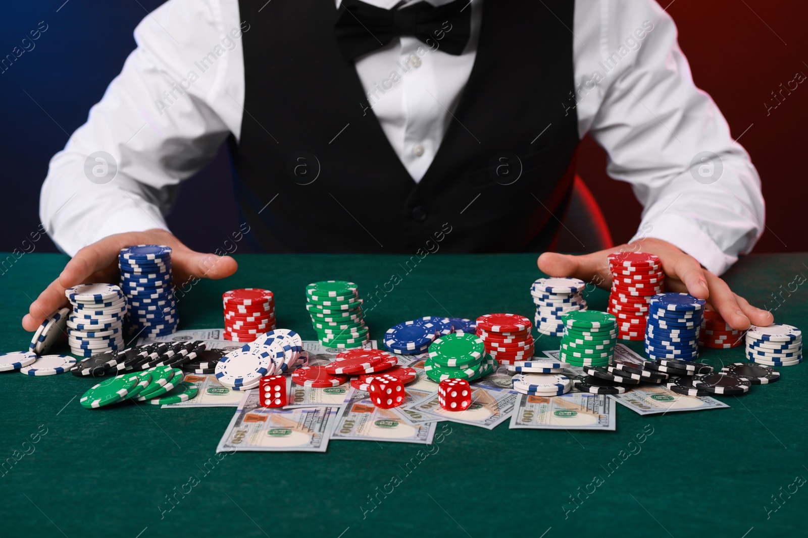 Photo of Professional croupier accepting bets at gambling table, closeup