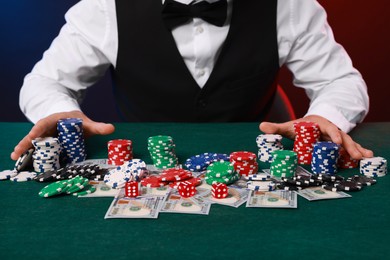 Photo of Professional croupier accepting bets at gambling table, closeup