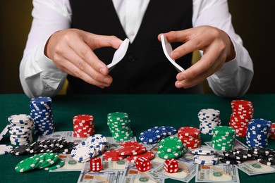 Photo of Professional croupier shuffling cards at gambling table, closeup