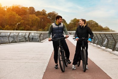 Photo of Beautiful happy couple with bicycles spending time together outdoors