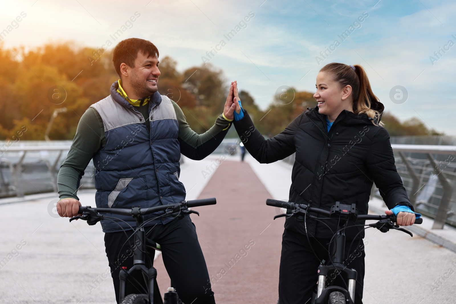 Photo of Beautiful happy couple with bicycles spending time together outdoors