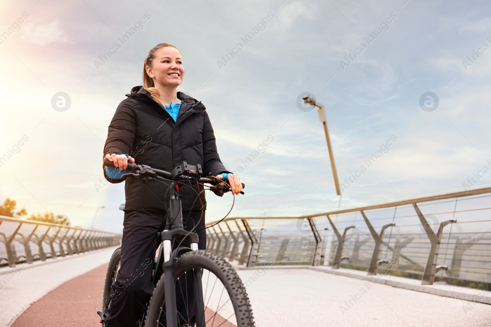 Photo of Woman with bicycle outdoors, space for text