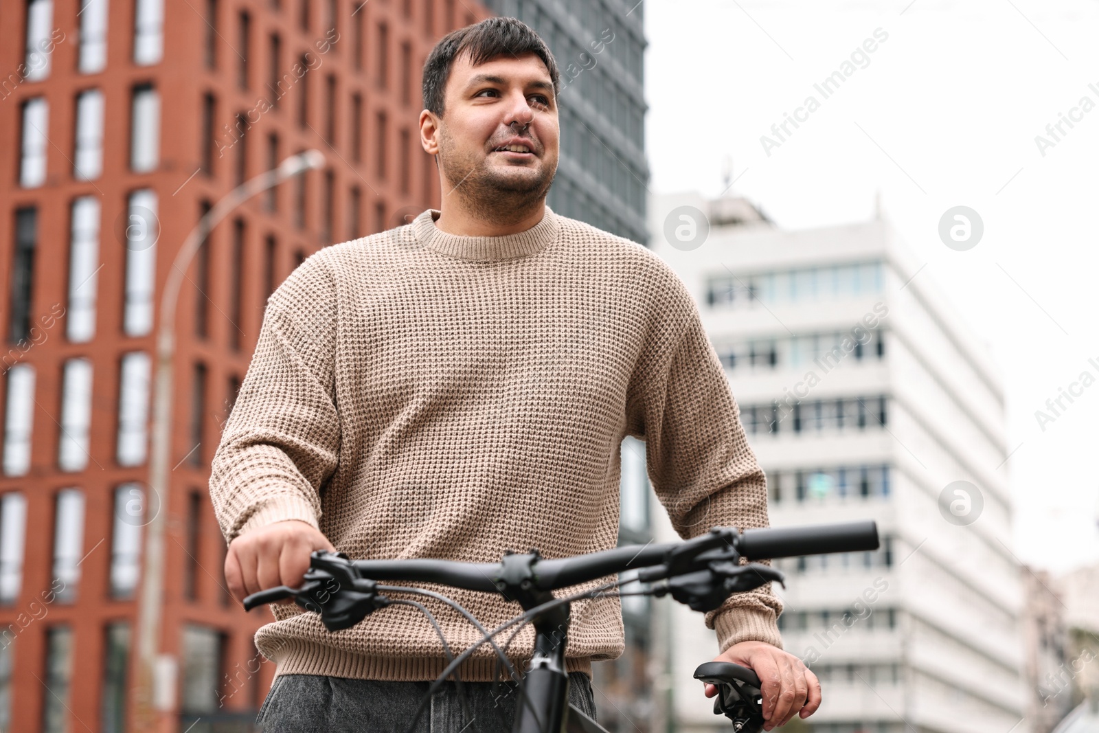 Photo of Handsome man with bicycle outdoors, low angle view. Healthy lifestyle