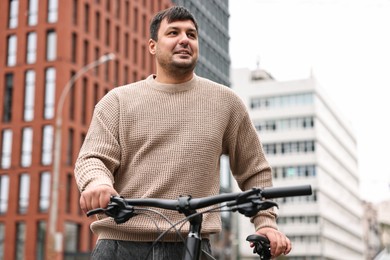 Photo of Handsome man with bicycle outdoors, low angle view. Healthy lifestyle