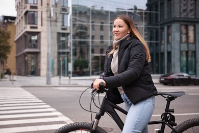 Photo of Woman with bicycle outdoors, space for text