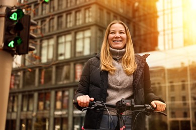 Photo of Beautiful woman with bicycle outdoors, low angle view. Space for text