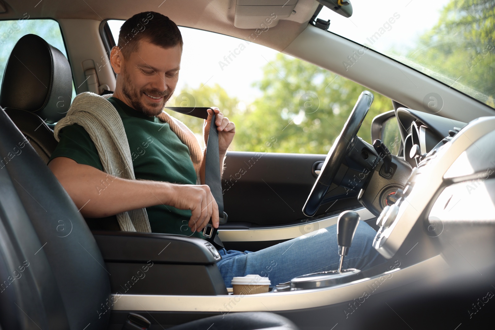 Photo of Man fastening seat belt in modern car