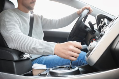 Man in gray sweater driving modern car, closeup view