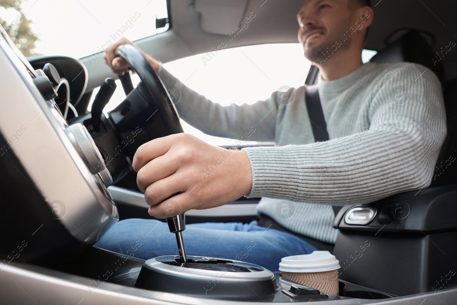 Photo of Man driving modern car, focus on gear stick