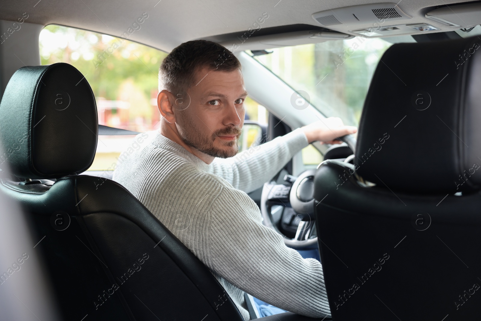 Photo of Man behind steering wheel of modern car