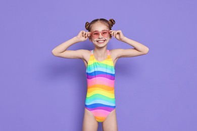 Photo of Happy girl in beachwear on purple background