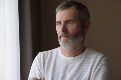 Photo of Portrait of lonely mature man at home