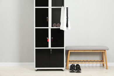 Photo of Lockers with personal belongings and bench in changing room at gym