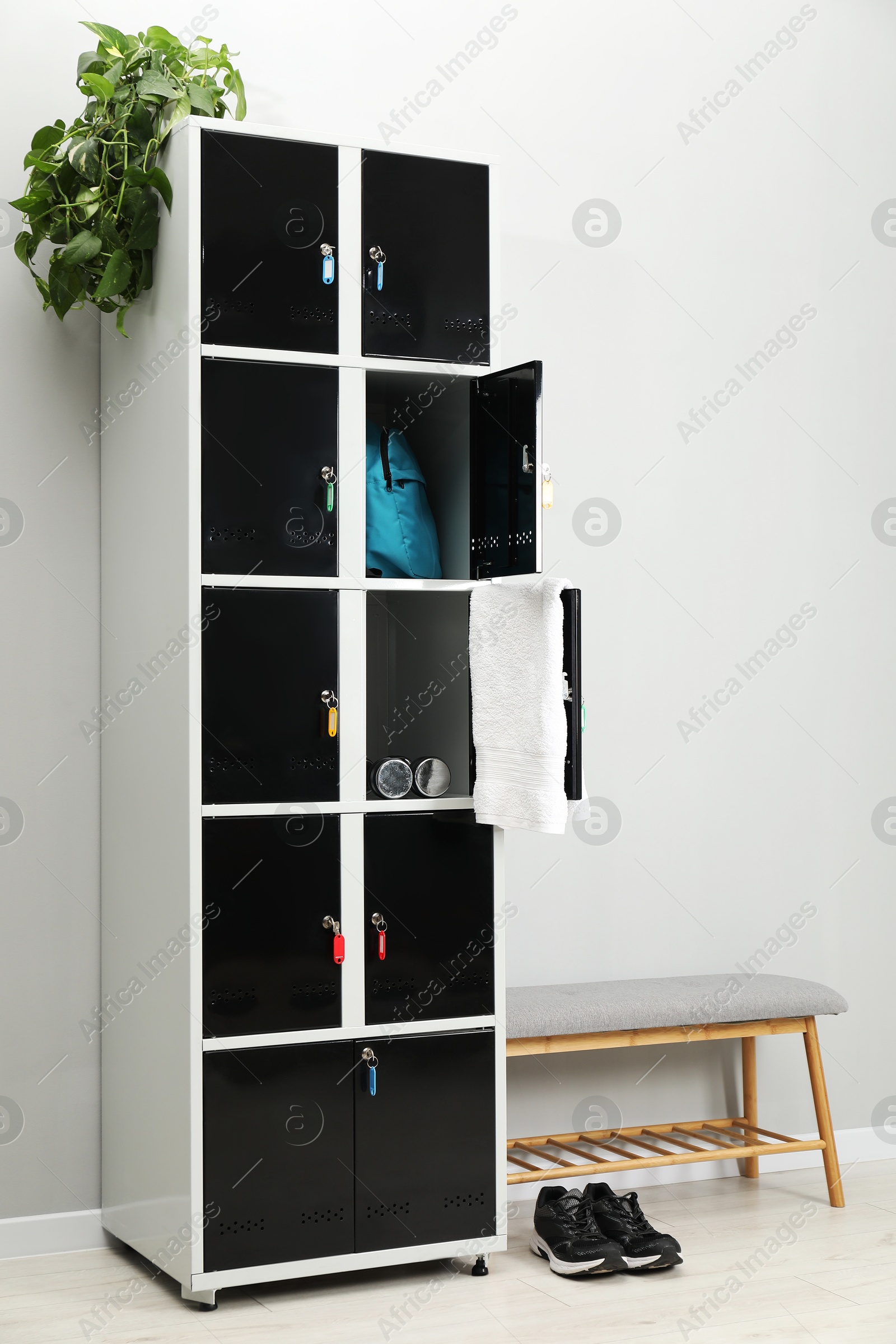 Photo of Lockers with personal belongings and bench in changing room at gym