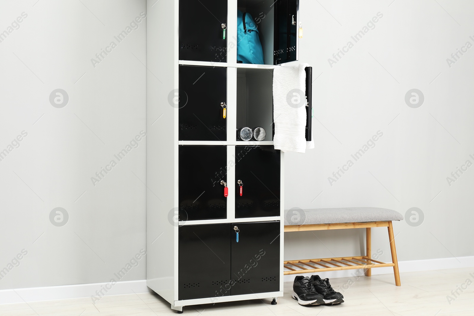 Photo of Lockers with personal belongings and bench in changing room at gym