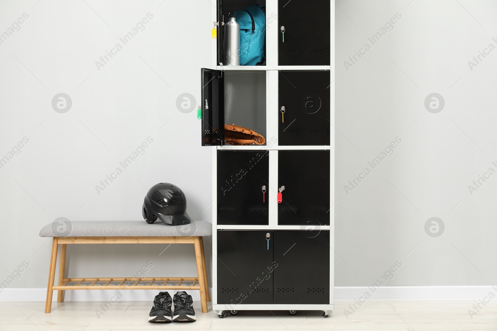 Photo of Lockers with personal belongings and bench in changing room at gym