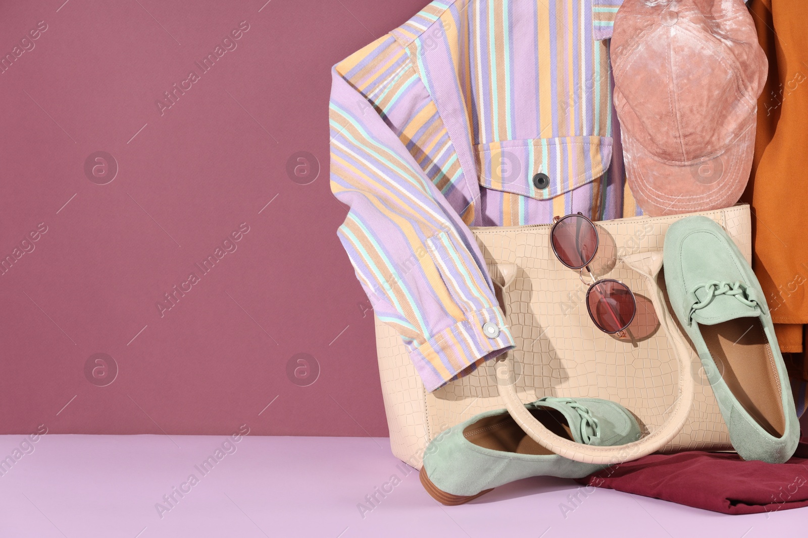 Photo of Clothes, shoes, bag and sunglasses on color background, space for text