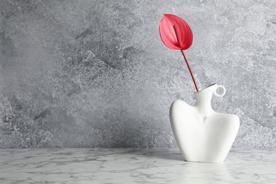 Photo of Beautiful tail flower in vase on marble table. Space for text