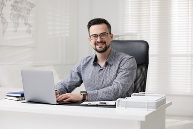 Portrait of smiling banker at table in office