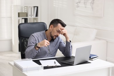 Photo of Tired banker working at table in office