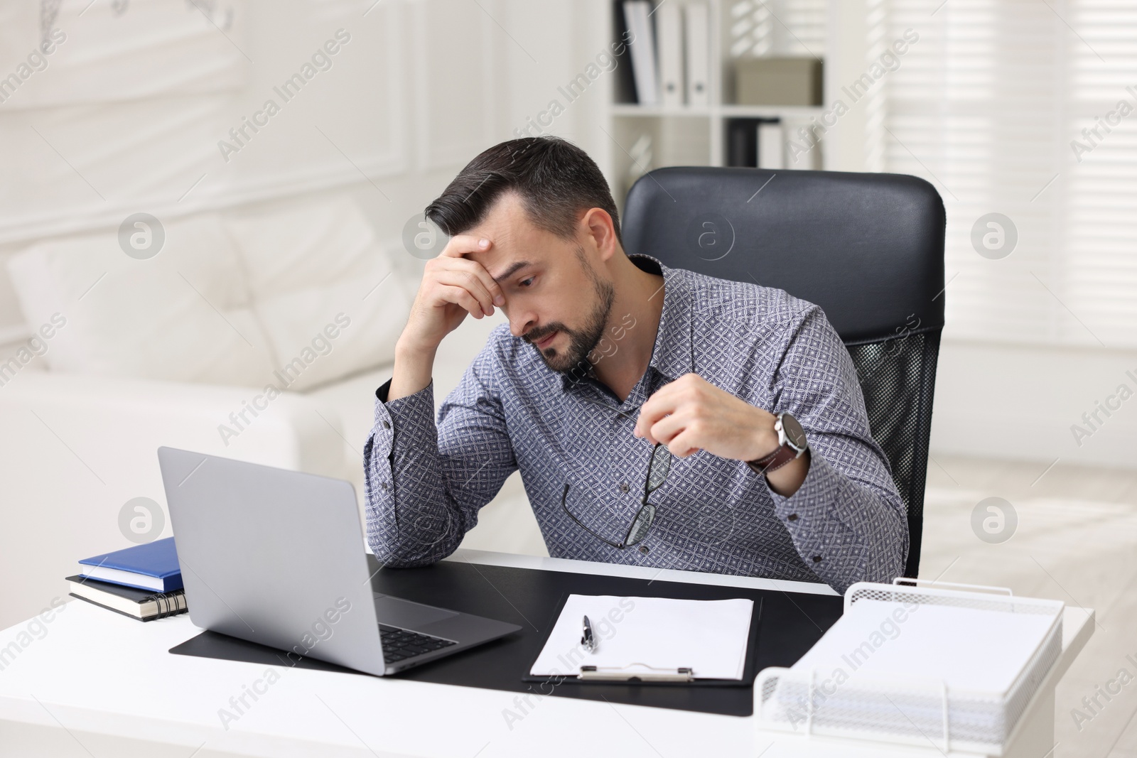 Photo of Tired banker working at table in office