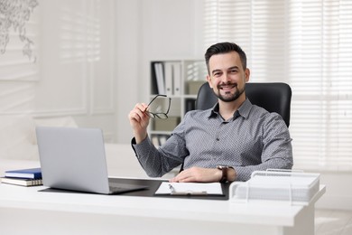 Photo of Portrait of smiling banker at table in office