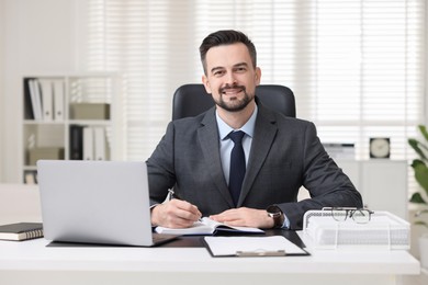 Photo of Portrait of smiling banker at table in office