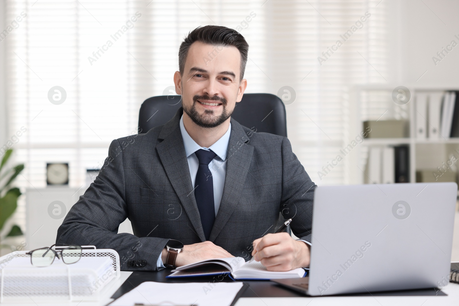 Photo of Portrait of smiling banker at table in office