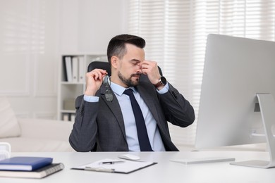 Photo of Tired banker sitting at table in office