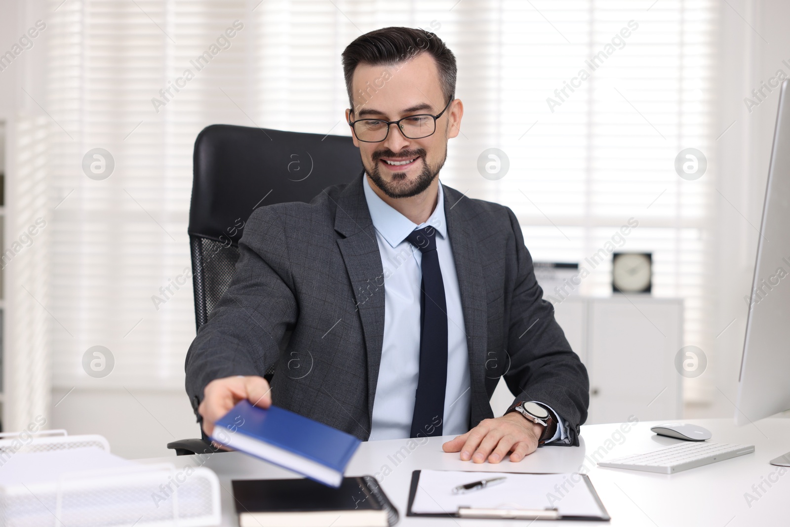 Photo of Smiling banker working at table in office